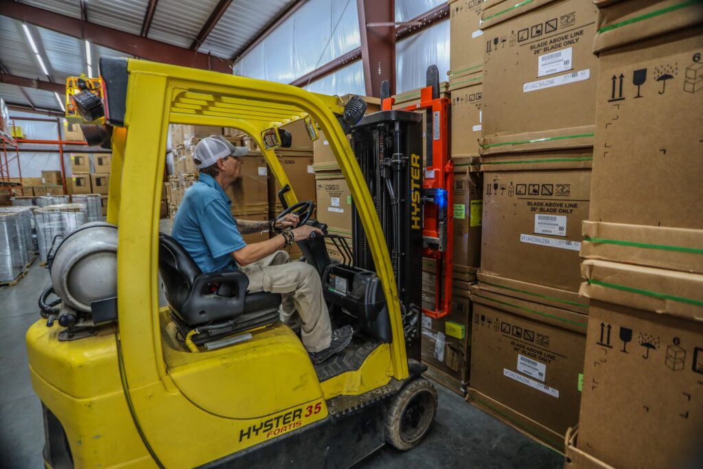 Buy Comfort Direct warehouse team member moving HVAC equipment with a forklift in Winder, Georgia
